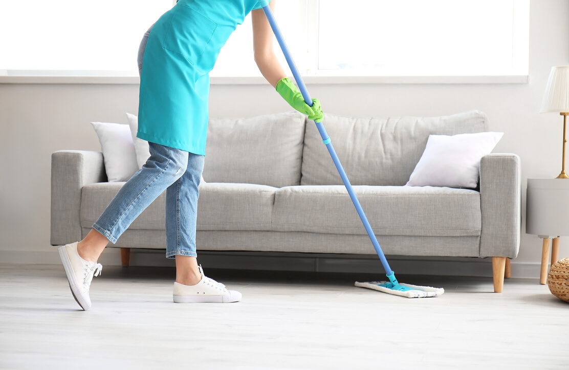 Young Woman Mopping Floor in Room